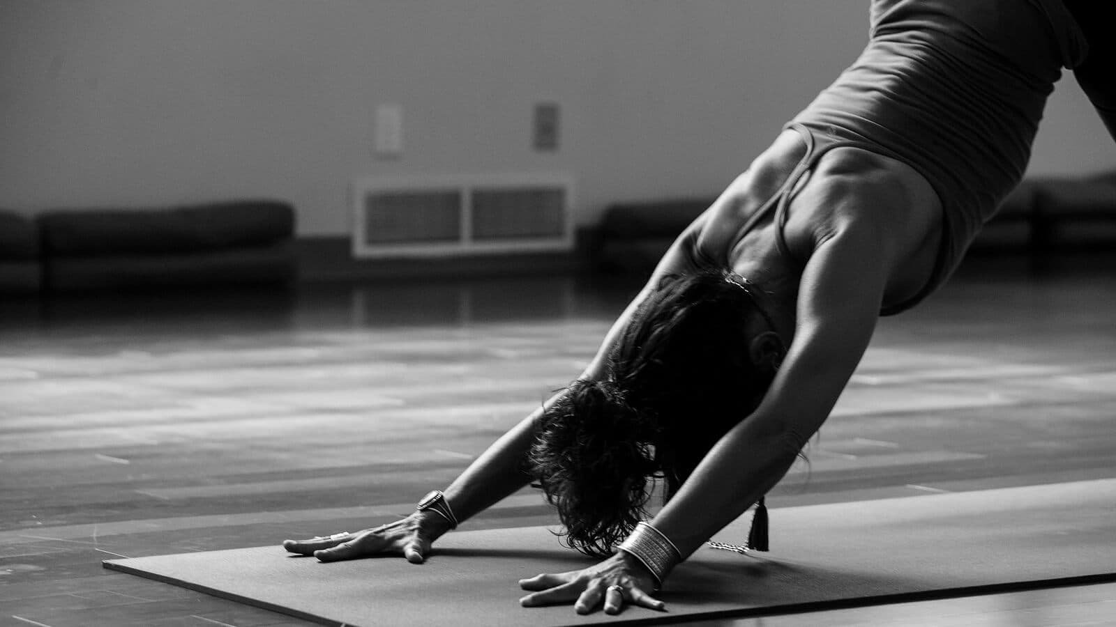Person in downward dog during a hot yoga class
